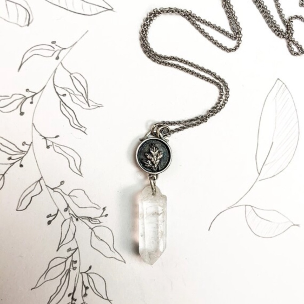 Silver cedar branch pendant with quartz crystal.